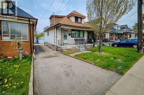 Single-story residence featuring light-colored siding and a gabled roofline - 463 Wellington Street N, Hamilton, ON - Outdoor