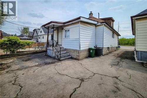 Rear exterior featuring white siding and a stone foundation - 463 Wellington Street N, Hamilton, ON - Outdoor