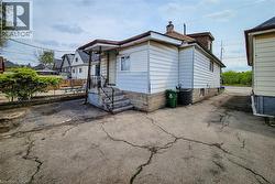 Rear exterior featuring white siding and a stone foundation - 