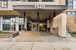 Building entrance featuring a contemporary portico, glass double doors, and a brick facade - 