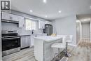 Contemporary kitchen featuring white cabinetry, stainless steel appliances, a center island with countertop seating, recessed lighting, and wood-finish flooring - 2367 Middlesmoor Crescent, Burlington, ON  - Indoor Photo Showing Kitchen 