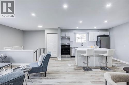Open-concept living space featuring a modern kitchen with a large island, stainless steel appliances, white cabinetry, and recessed lighting - 2367 Middlesmoor Crescent, Burlington, ON - Indoor