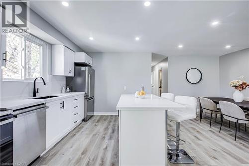 Modern kitchen featuring white cabinetry, light countertops, stainless steel appliances, wood-finish flooring, and recessed lighting - 2367 Middlesmoor Crescent, Burlington, ON - Indoor Photo Showing Kitchen