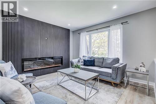 Accent wall featuring vertical slat paneling and a built-in linear fireplace - 2367 Middlesmoor Crescent, Burlington, ON - Indoor Photo Showing Living Room