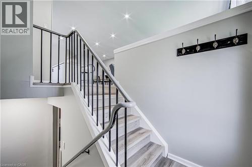 Staircase featuring wood-finish treads, white risers, and black metal balusters with a coordinating handrail - 2367 Middlesmoor Crescent, Burlington, ON - Indoor Photo Showing Other Room