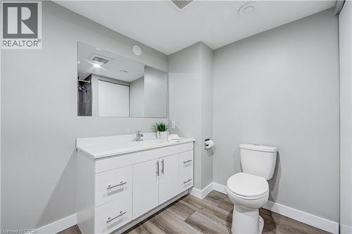 Bathroom featuring a white vanity with silver hardware, an integrated countertop sink, and a large wall-mounted mirror - 2367 Middlesmoor Crescent, Burlington, ON - Indoor Photo Showing Bathroom