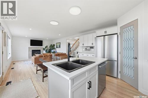 402 Crystal Bay, Warman, SK - Indoor Photo Showing Kitchen With Fireplace With Stainless Steel Kitchen With Double Sink