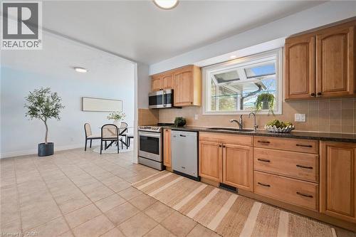 Contemporary kitchen featuring wood cabinetry, stainless steel appliances, and a window above the sink - 176 Woodville Place, Waterloo, ON - Indoor Photo Showing Kitchen