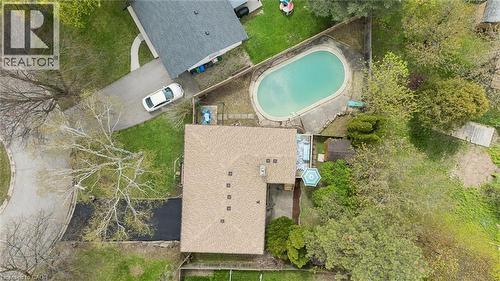 Oval in-ground swimming pool with surrounding concrete decking - 176 Woodville Place, Waterloo, ON - Outdoor With View