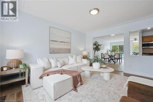 Open-concept living area featuring light wood-finish flooring, light blue wall finishes, and recessed ceiling lighting - 176 Woodville Place, Waterloo, ON - Indoor Photo Showing Living Room