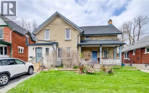 Brick facade residence featuring a front lawn and a covered porch with white railings - 46 Shanley Street, Kitchener, ON - Outdoor