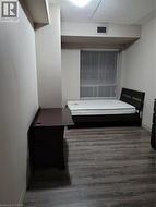 Spacious room featuring wood-finish flooring, a large window with blinds, and a built-in ventilation system - 