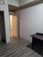 Room featuring wood-finish flooring, light gray walls, and white trim - 