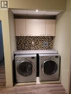 Dedicated laundry area featuring wood-finish flooring and recessed lighting - 