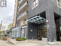 Modern multi-story building featuring a dark brick facade and lighter paneling - 
