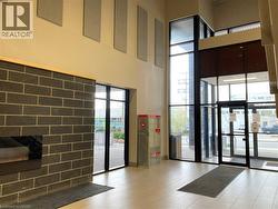 Lobby entrance featuring a black brick accent wall, high ceilings, and floor-to-ceiling windows - 
