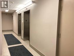 Contemporary hallway featuring two stainless steel elevators - 