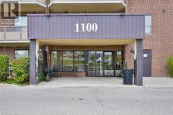 Brick facade building with a prominent covered entrance, large glass doors, and a concrete approach - 