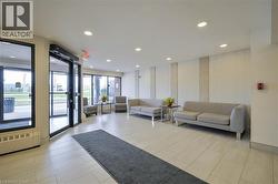 Spacious lobby featuring recessed lighting, light-toned tile flooring, textured accent walls, and expansive storefront windows - 