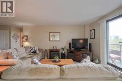 Living area featuring neutral wall tones, a built-in electric fireplace with mantel, and wood-finish entertainment cabinetry - 