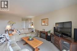 Open-concept living space featuring neutral-toned carpeting and walls - 