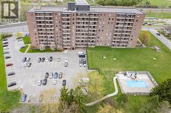 Multi-story building featuring brick cladding, individual balconies, and a flat roof - 