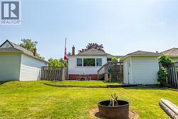 Expansive backyard featuring a manicured lawn, a detached storage shed, and a privacy fence - 