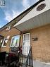 Brick exterior featuring a white entry door, black wrought iron railing, and prominent soffit with decorative octagon accent **Virtually Staged** - 148 Bishop Street S, Cambridge, ON 