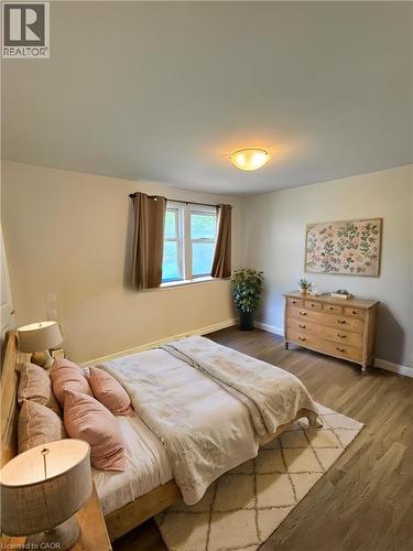 Spacious room featuring wood-finish flooring, a flush-mount ceiling light, and a double window **Virtually Staged** - 148 Bishop Street S, Cambridge, ON 