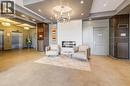 Modern lobby featuring a stacked stone fireplace, a contemporary chandelier, and recessed lighting - 191 King Street S Unit# 607, Waterloo, ON 