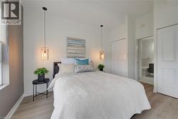 Bedroom featuring wood-finish flooring, two bi-fold closet doors, and recessed lighting - 