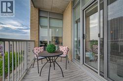 Private balcony featuring a light grey textured floor, painted metal railing, and brick exterior - 