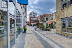 Paved courtyard featuring a variety of commercial storefronts with large glass windows and brick facades - 