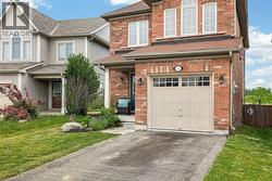 Brick exterior with a prominent single-car garage and a paved driveway - 