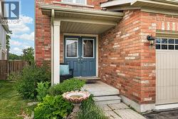 Brick exterior featuring a covered porch with white columns, dual blue entry doors with decorative glass inserts, and an attached garage with a panelized door and upper window sections - 