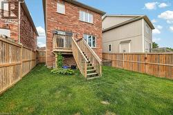 Expansive backyard featuring a manicured lawn, full wood privacy fencing, and a multi-level wooden deck with stairs - 
