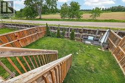 Expansive backyard featuring a manicured lawn, wood fencing, and mature plantings - 