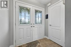 Double entry doors featuring decorative leaded glass panels and dual door handles - 