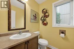 Vanity with a built-in sink, laminate countertop, and wood-finish cabinetry - 