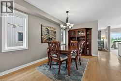 Dining area featuring light wood-finish flooring, neutral wall tones, and a white-trimmed window - 