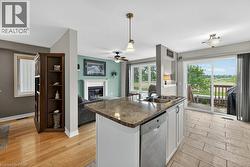 Kitchen island with a granite-style countertop, integrated double sink, and a built-in dishwasher - 
