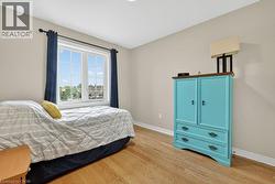 Spacious room featuring wood-finish flooring, neutral wall tones, and white trim - 