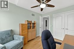 Room featuring wood-finish flooring, a ceiling fan with integrated lighting, and light-colored walls - 