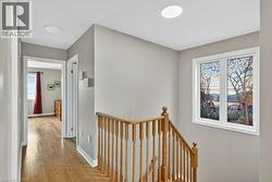 Staircase with wood-finish balustrade and handrail, featuring a decorative window with a scenic motif - 