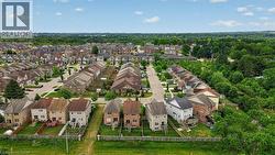Expansive residential community featuring a variety of detached and semi-detached homes, numerous mature trees, a network of paved streets, and residential fencing - 