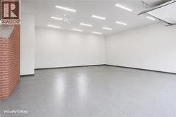 Spacious interior with durable epoxy flooring, bright overhead lighting, and a prominent brick accent wall - 
