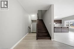 The property features a spacious entryway with light-colored flooring, leading to a dark wood staircase - 