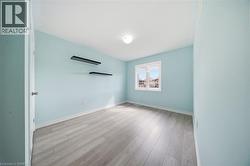 Room with light blue walls, light-colored flooring, and a single window providing natural light - 