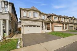 The property features a stone and siding exterior with a two-car garage and an asphalt driveway - 