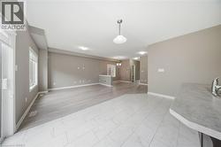 The property features an open living area with light-colored flooring, neutral wall tones, and several windows providing natural illumination - 